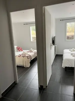 a room with two beds and two windows at A nepita di porto vecchio*** in Porto-Vecchio