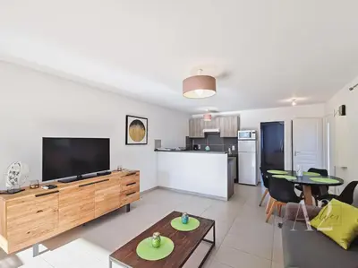 a living room with a television and a table at Appartement 4 Pers - Cala Rossa - Piscine in Lecci
