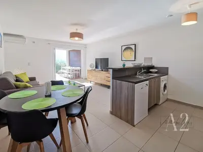 a kitchen and a living room with a table and chairs at Appartement 4 Pers - Cala Rossa - Piscine in Lecci