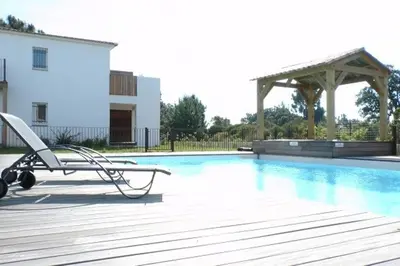 a swimming pool with a chair and a wooden deck at Appartement 4 Pers - Cala Rossa - Piscine in Lecci