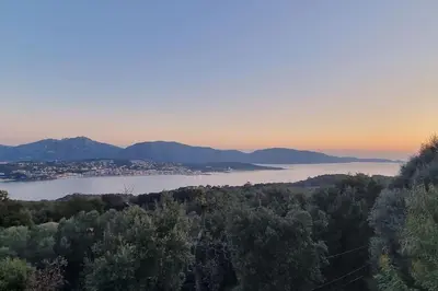 a view of a lake with a city and mountains at Maison avec jacuzzi in Olmeto