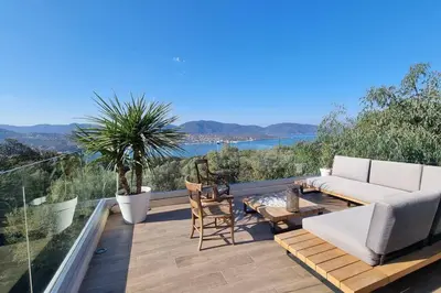 a patio with a couch and a table and chairs at Maison avec jacuzzi in Olmeto