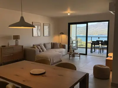 a living room with a couch and a table at Appartement tout confort vue mer in Propriano