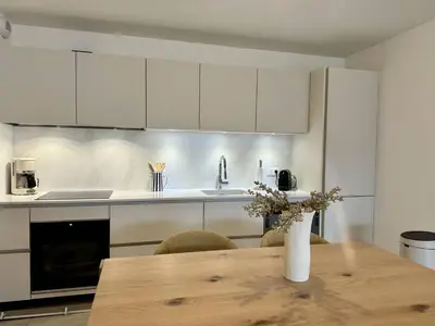 a kitchen with a wooden table and a vase with flowers at Appartement tout confort vue mer in Propriano