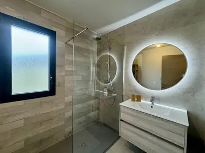 a bathroom with a sink and a mirror at Appartement tout confort vue mer in Propriano