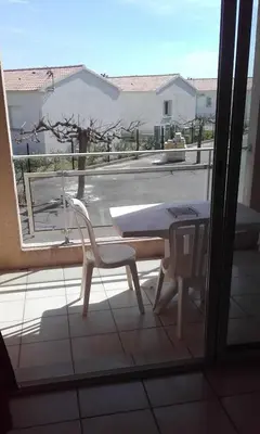 a table and chairs on a balcony with a view of a street at Haute Corse. Studio 4 pers .Plage Piscine. Cervione Prunete . in Cervione