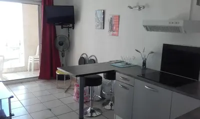 a kitchen with a black counter top in a room at Haute Corse. Studio 4 pers .Plage Piscine. Cervione Prunete . in Cervione