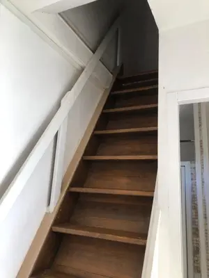 a staircase in a house with white walls and wooden floors at Maison de charme entre mer et montagne in Forciolo