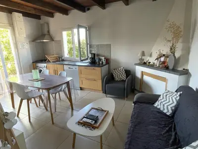 a kitchen and living room with a couch and a table at Maison de charme entre mer et montagne in Forciolo