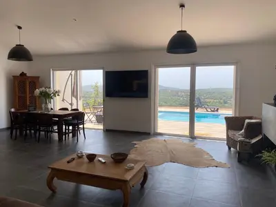 a living room with a table and a dining room at Villa avec piscine 3 étoiles proche plages in Monacia-dʼAullène
