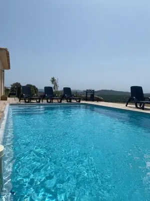 a swimming pool with chairs and blue water at Villa avec piscine 3 étoiles proche plages in Monacia-dʼAullène