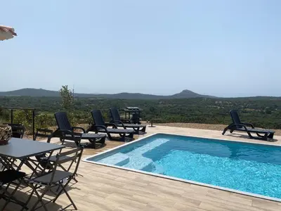 a swimming pool with chairs and a table with a view at Villa avec piscine 3 étoiles proche plages in Monacia-dʼAullène