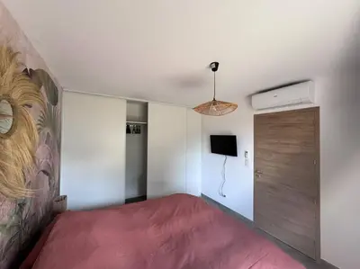 a bedroom with a large red bed and a door at Maison Joepolly corsica in Bonifacio