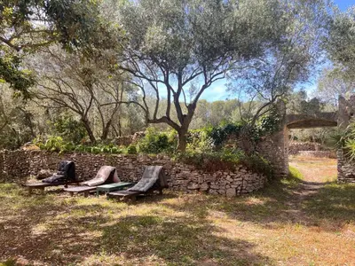 a stone wall with a picnic table in a yard at tour casella in Bonifacio
