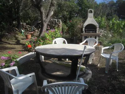 a table and chairs in a yard with a bird house at CASA DI SIGNARE in Ventiseri