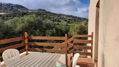 a wooden bench on a balcony with a view of a mountain at Location L'épi d'or Calvi, demeure de charme in Calvi