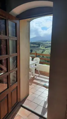 an open door to a balcony with a table and chairs at Location L'épi d'or Calvi, demeure de charme in Calvi