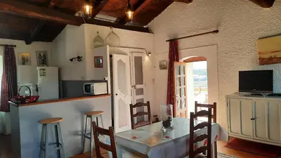 a kitchen and dining room with a table and chairs at Location L'épi d'or Calvi, demeure de charme in Calvi