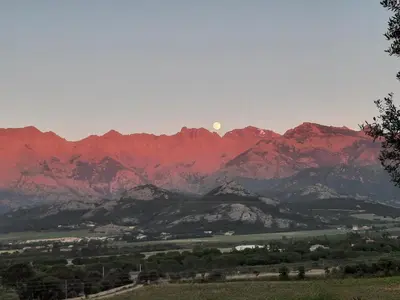 a view of a mountain range with the moon in the sky at Location L'épi d'or Calvi, demeure de charme in Calvi