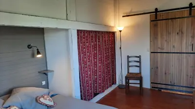 a bedroom with a bed and a ladder and a chair at Location L'épi d'or Calvi, demeure de charme in Calvi