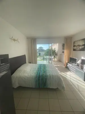 a bedroom with a bed and a view of a patio at Studio 28 m2 PORTICCIO Centre in Porticcio