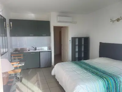 a bedroom with a bed and a sink and a kitchen at Studio 28 m2 PORTICCIO Centre in Porticcio