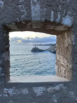 a view of the ocean through a stone window at Appartement Orenaggio in Bonifacio