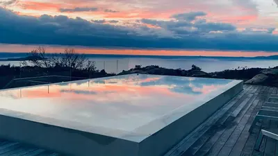 a swimming pool on top of a building with a sunset at 1,2,3 soleil in Porticcio