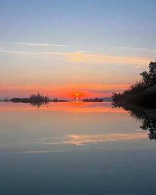 a sunset over a large body of water at 1,2,3 soleil in Porticcio