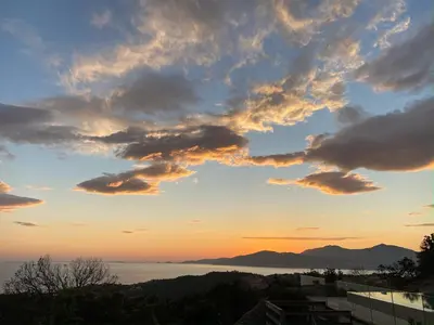 a sunset view of the water and mountains at 1,2,3 soleil in Porticcio