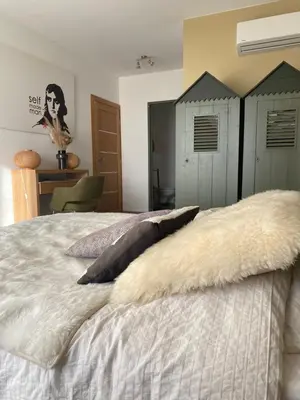 a bedroom with a bed with white sheets and pillows at 1,2,3 soleil in Porticcio