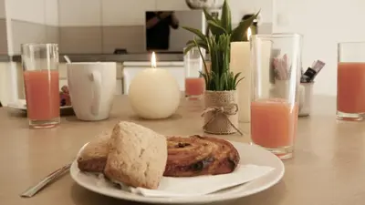 a plate with a piece of bread on a table with candles at Capstay studio avec grande terrasse proche aéroport Bastia - Lucciana - Centre in Lucciana