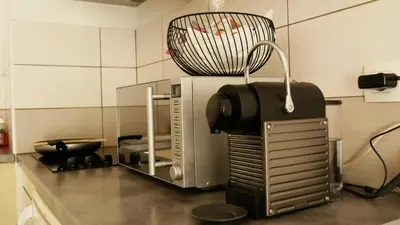 a kitchen with a microwave on top of a counter at Capstay studio avec grande terrasse proche aéroport Bastia - Lucciana - Centre in Lucciana