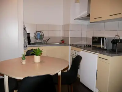a small kitchen with a wooden table and chairs at Capstay studio avec grande terrasse proche aéroport Bastia - Lucciana - Centre in Lucciana