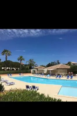 a large swimming pool with lounge chairs at Appartement dans résidence in Linguizzetta