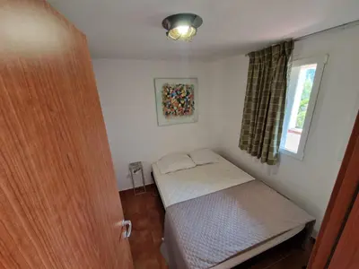 a small room with a bed and a window at Appartement dans résidence in Linguizzetta