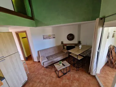 a living room with a couch and a table at Appartement dans résidence in Linguizzetta