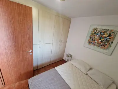a bedroom with a bed and a painting on the wall at Appartement dans résidence in Linguizzetta