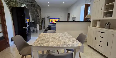 a kitchen and dining room with a table and chairs at Charmante Maison de village, Proche Aéroport in Lucciana