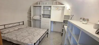 a small room with a bed in a kitchen at Charmante Maison de village, Proche Aéroport in Lucciana