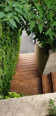 a brick walkway in a garden with plants at Charmante Maison de village, Proche Aéroport in Lucciana