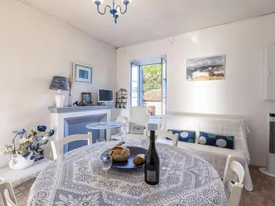 a dining room with a table with a bottle of wine at Apartment Santa by Interhome in Porto-Vecchio