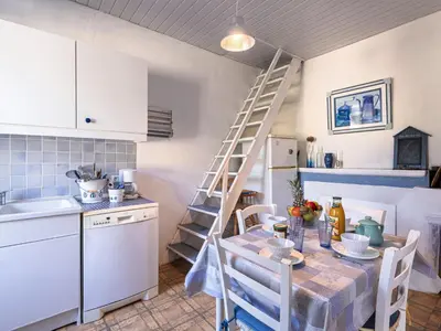 a kitchen with a table and a kitchen with a ladder at Apartment Santa by Interhome in Porto-Vecchio