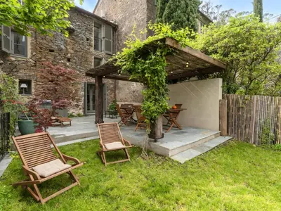 a patio with two chairs and a table in a yard at Holiday Home Casa Serena by Interhome in San-Giuliano