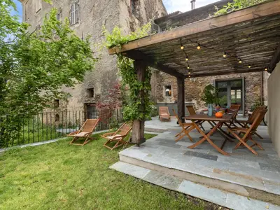 a patio with a wooden table and chairs in a yard at Holiday Home Casa Serena by Interhome in San-Giuliano