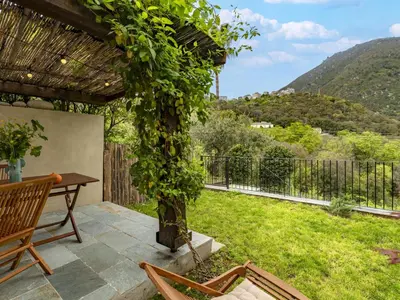 a patio with a table and chairs and a tree at Holiday Home Casa Serena by Interhome in San-Giuliano
