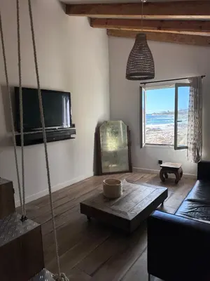 a living room with a couch and a table at Casa Mare, CABANON SUR LA PLAGE à Ajaccio vue sanguinaires in Ajaccio