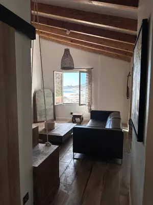 a living room with a couch and a window at Casa Mare, CABANON SUR LA PLAGE à Ajaccio vue sanguinaires in Ajaccio