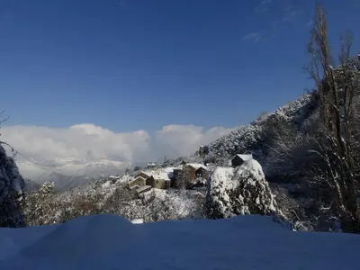 a snow covered mountain with a house on it at Chambre d'Hôtes La Marlotte in Castello-di-Rostino