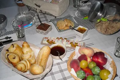 a table with two baskets of different types of bread and fruit at Chambre d'Hôtes La Marlotte in Castello-di-Rostino